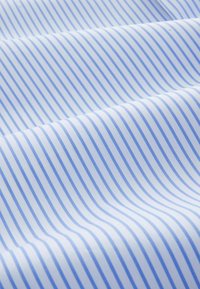 Tissu en coton présentant de fines rayures bleu et blanc, texture lisse, avec des plis créant un motif ondulé sur la surface.
