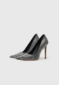 Black high-heeled shoes adorned with silver rhinestones, pointed toe design, and a smooth interior texture.