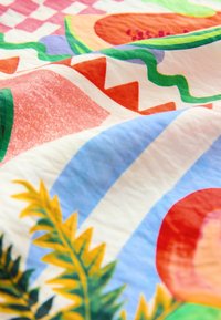 Tessuto vivace con motivi astratti in rosso, verde e blu. Testurizzato con una finitura liscia e caratterizzato da notevoli motivi di piante e frutti.