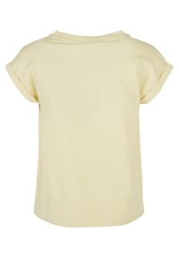 T-shirt giallo a maniche corte realizzato in cotone morbido. Presenta una vestibilità rilassata, scollo rotondo e design con risvolto. Senza pattern o accenti visibili.