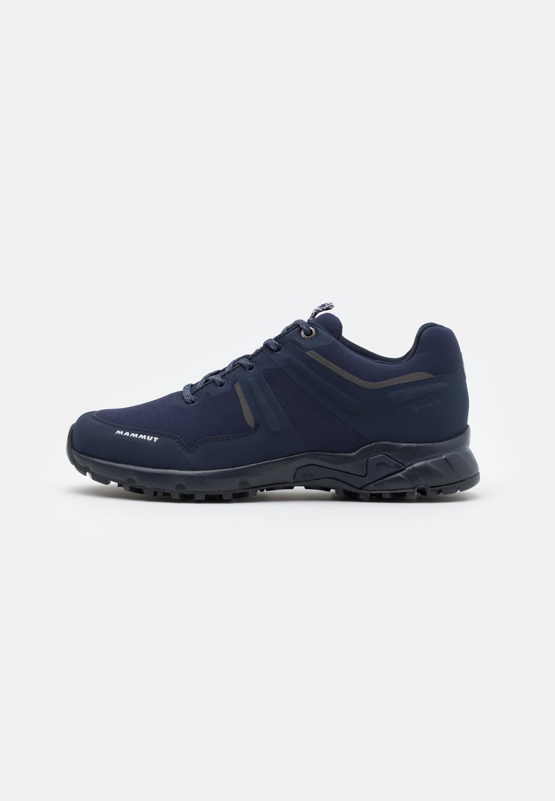 Chaussure de randonnée basse bleu foncé avec semelle noire, fermeture à lacets sur l'avant et marquage subtil sur le côté et le bout.