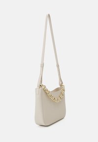 Borsa a spalla in pelle beige con accento in catena dorata, forma strutturata e tracolla regolabile. Superficie testurizzata con dettagli minimi.