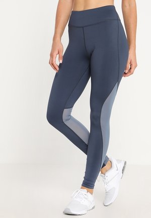 Granatowe legginsy z wysokim stanem, eleganckim krojem i jasnoszarymi akcentami z siatki po bokach. Wykonane z elastycznego, gładkiego materiału.