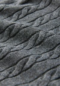Grauer Strickstoff mit einem sich wiederholenden Zopfmuster und sichtbarer Textur aus weichen Garnfasern.