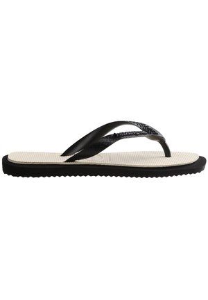 Schwarze Flip-Flops mit strukturierten schwarzen Riemen und einer beigen Fußbett. Merkmale einer geriffelten schwarzen Sohle für besseren Halt. Leichtes Design.