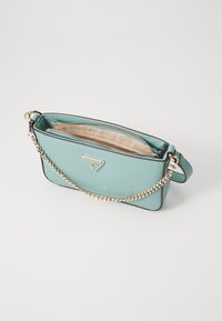 Sac bandoulière vert menthe avec une surface texturée, une chaîne dorée et un compartiment zippé. Présente un détail de logo à l'avant.