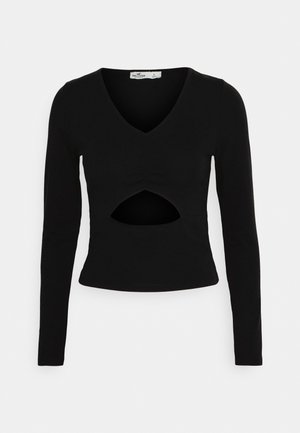 Μαύρη μπλούζα με μακρύ μανίκι, V-λαιμόκοψη και σκίσιμο στη μέση. Φτιαγμένη από λείο ύφασμα με στενή εφαρμογή. Μεγέθους μικρού.