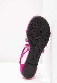 Sandale rose pour enfant avec semelle noire et motifs circulaires, taille 37, positionnée debout sur fond blanc.