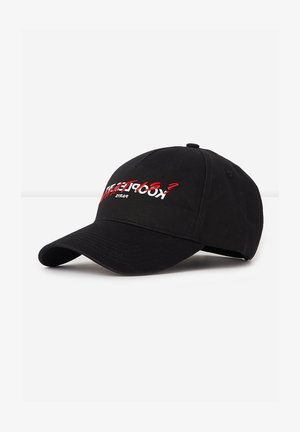 Black baseball cap made of fabric with a curved brim. Features white and red embroidered text on the front. Adjustable back strap.