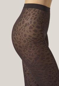 Genomskinliga svarta leggings med ett subtilt mönster av leopardprint, texturerad tyg, hög midja och en åtsittande design som framhäver formen.