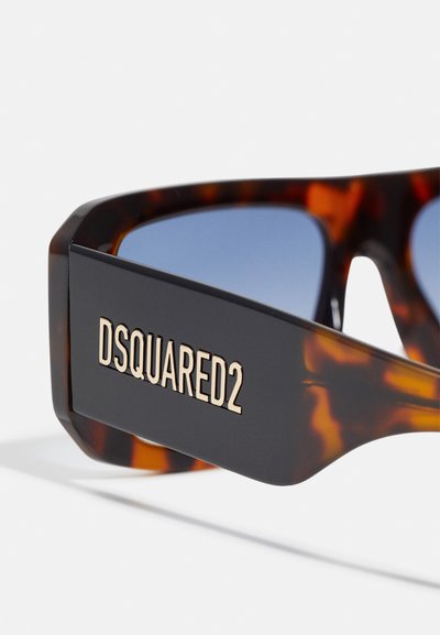 Solariji s uzorkom kornjače i tamnim okvirom, koji imaju plave leće i zlatni "DSQUARED2" logo s boka.