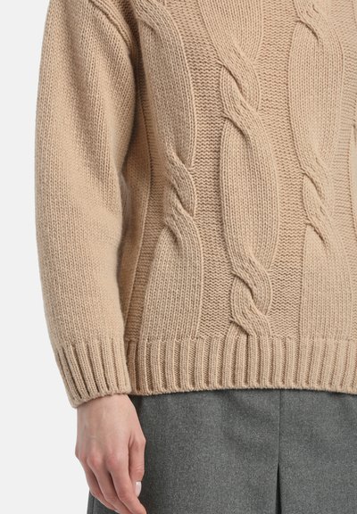 Pulover tricotat bej, cu un design din tricot cu care, cu manșete și tiv cu nervuri. Materialul are un aspect moale și texturat.