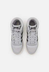 Gray high-top sneakers with black stripes, textured leather upper, perforated toe box, and a cream-colored rubber outsole.