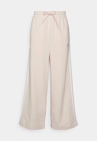 Pantalones deportivos de pierna ancha de color rosa claro, confeccionados con tela suave, cuentan con una cintura elástica con cordón y rayas laterales blancas. Pequeño logo en la cadera.