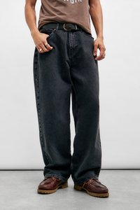 Svarte denimbukser med løs passform og lett falming, med beltehemper og sidelommer, sammen med brune lærsko.