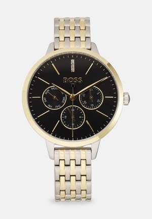 Montre en métal argenté et doré avec un cadran noir, des accents dorés, trois sous-cadrans et un design de bracelet à maillons. Présente un affichage de la date.