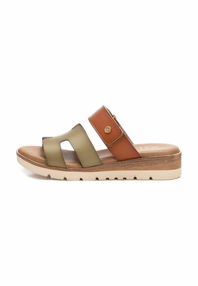 Sandalias tipo slide bicolor con correas de cuero en verde oliva y marrón, plantilla acolchada y suela de plataforma con aspecto de madera y ranuras.