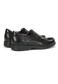 Zapatos de cuero negro sin cordones con un acabado texturizado, puntera redondeada, acentos elásticos y detalles de costura curvada sobre una suela flexible.