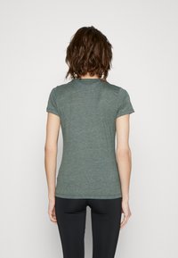 Kortärmad grön t-shirt med en figursydd design, tillverkad av mjukt tyg, med rundad halslinning och en mjuk textur.