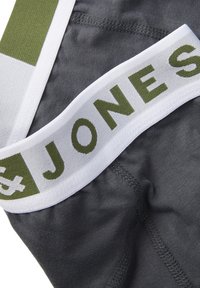 Boxers en textile gris avec une taille blanche comportant l'inscription "JONES" en vert. Matériau doux avec des coutures lisses et une étiquette.