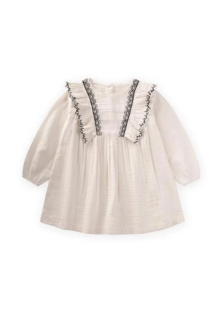 Robe en coton blanc à manches longues, bordure noire à volants le long de l'encolure, et corsage froncé pour une silhouette fluide.