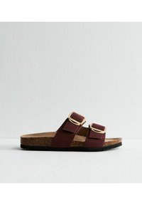 Bruna korkfotb�äddsandaler med två vinröda mockaband, som har guldfärgade spännen och texturerade svarta gummisulor.