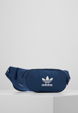 Granatowa saszetka Adidas z białym logo trefoil, główna komora na zamek i regulowany pasek, prezentowana na białej powierzchni.