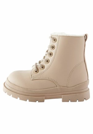 Bottine beige à lacets avec semelle épaisse crantée et doublure intérieure douce, conçue pour la durabilité et la chaleur.