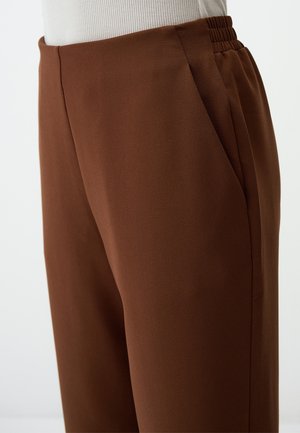Pantaloni brown a vita alta con una superficie liscia, dotati di tasche laterali e una vita elastica per il massimo comfort.