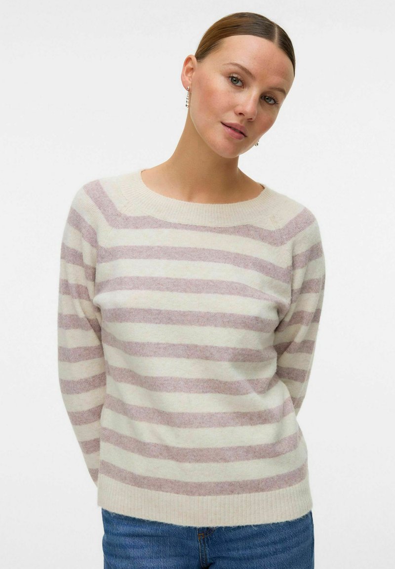 Maglione di lana a righe con strisce orizzontali color beige chiaro e lavanda morbido. Collo tondo e orlo a costine, abbinato a jeans blu.