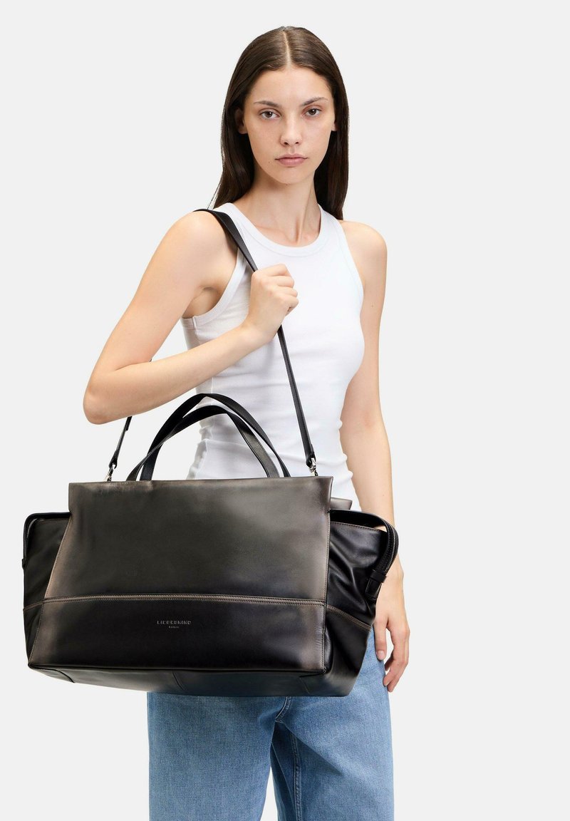 Schwarze Lederhandtasche mit doppelten Griffen und verstellbarem Schultergurt. Verfügt über ein elegantes, glattes Finish mit einem Reißverschlussfach.