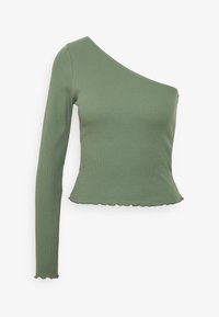 Green ribbed top featuring one long sleeve, an asymmetrical neckline, and a scalloped hem. Made of a soft, stretchy material.