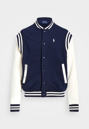 Chaqueta varsity azul marino y blanca con puños y cuello a rayas, botones delanteros de presión y logo de Polo Ralph Lauren en el pecho.