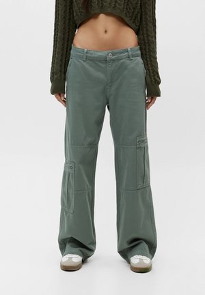 Pantalon cargo vert clair à coupe décontractée, avec grandes poches latérales, détails de coutures et tissu léger en mélange de coton.