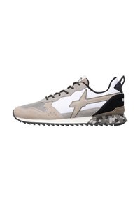 Vista laterale di una sneaker atletica grigia, bianca e nera con suola a motivo mimetico e design a zig-zag beige sul lato.