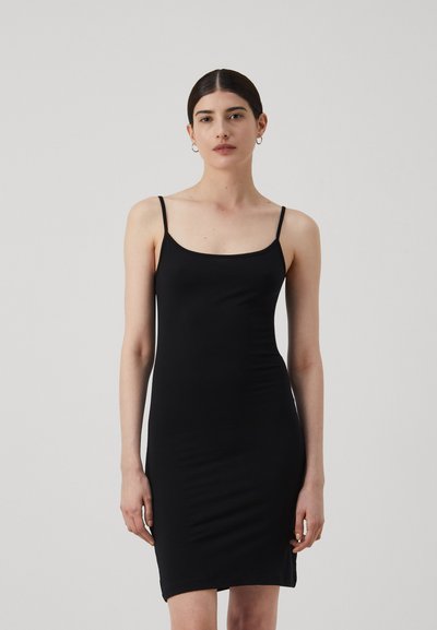 Robe noire ajustée en tissu lisse, dotée de fines bretelles et d'un décolleté arrondi, se terminant au milieu des cuisses avec un minimum de détails.