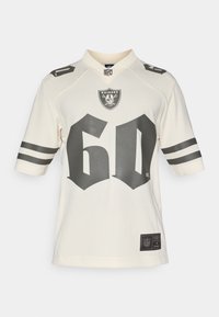 Kremowa koszulka NFL z logo Raiders, wyboldowanym czarnym "60" na przodzie i czarno-białymi paskami na rękawach. Gładki, oddychający materiał.