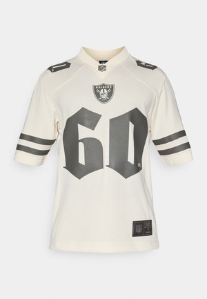 Kremowa koszulka NFL z logo Raiders, wyboldowanym czarnym "60" na przodzie i czarno-białymi paskami na rękawach. Gładki, oddychający materiał.