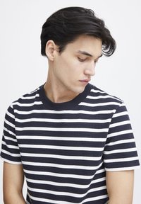 Navy and white striped short-sleeve t-shirt with a crew neckline, featuring a textured fabric and a fitted cut.