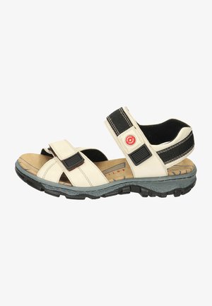 Beige Sandalen mit Lederriemen, schwarzen Klettverschlüssen, einer beigefarbenen gepolsterten Fußbett und einer strukturierten Gummisohle für guten Halt.