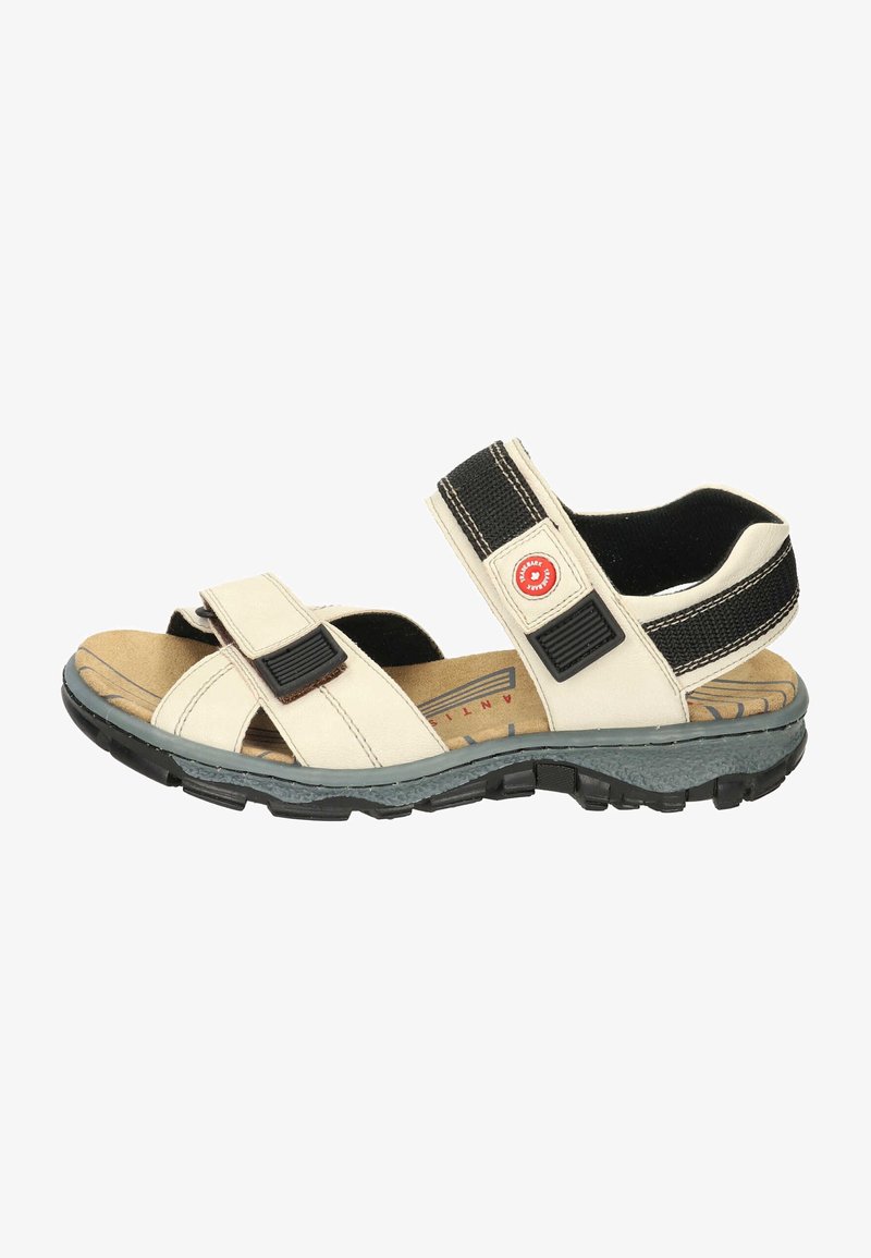 Beige sandals with leather straps, black velcro closures, a tan cushioned footbed, and a textured rubber outsole for grip.