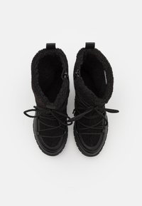 Botas negras con un upper de textura suave, dos cremalleras laterales y cordones negros. La suela es de goma con un patrón de agarre texturizado.