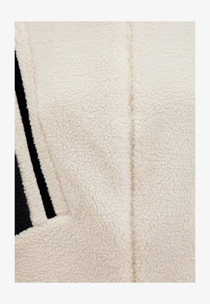 Cream fleece fabric with a soft, textured surface. Features a central seam and black striped accents along one side.