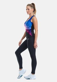 Leggings negre asortați cu un top fără mâneci, având un design în gradient de la albastru la mov și modele cu stele. Pantofi sport albi completează ținuta.