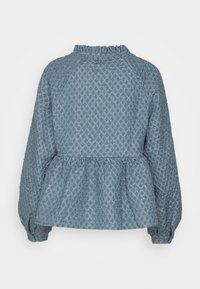 Blusa peplum blu texturizzata con maniche lunghe, caratterizzata da un colletto arricciato e un tessuto a motivo con design a diamante.