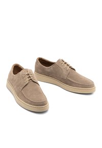 Beżowe zamszowe buty o niskim kroju, okrągłym nosku i pięcioma oczkami na sznurówki. Gumowa podeszwa zapewniająca dodatkowy komfort i trwałość.