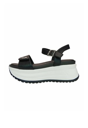 Sandalo platform in pelle nera con cinturino alla caviglia regolabile, suola bianca spessa e cinturino frontale in velcro con dettaglio logo metallico.