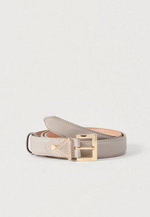 Ceinture gris clair texturée avec une boucle métallique dorée et un accent de logo triangulaire. Doublure intérieure lisse, design fin.