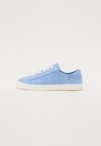 Sneakers in tela blu con suole in gomma bianca, una finitura texture e lacci bianchi. Presentano un piccolo logo sul lato e un design a taglio basso.