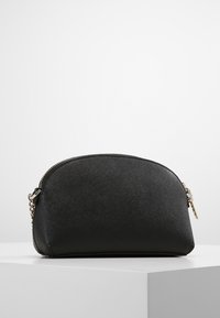 Černá texturovaná kosmetická taška, semicirkulární tvar, s uzávěrem na zip a zlatým kováním, na jedné straně s řetízkem.